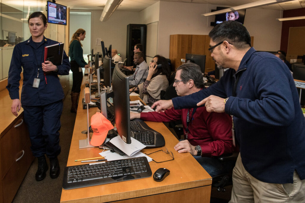 Centro de operaciones con personal técnico monitoreando computadoras durante una situación de emergencia