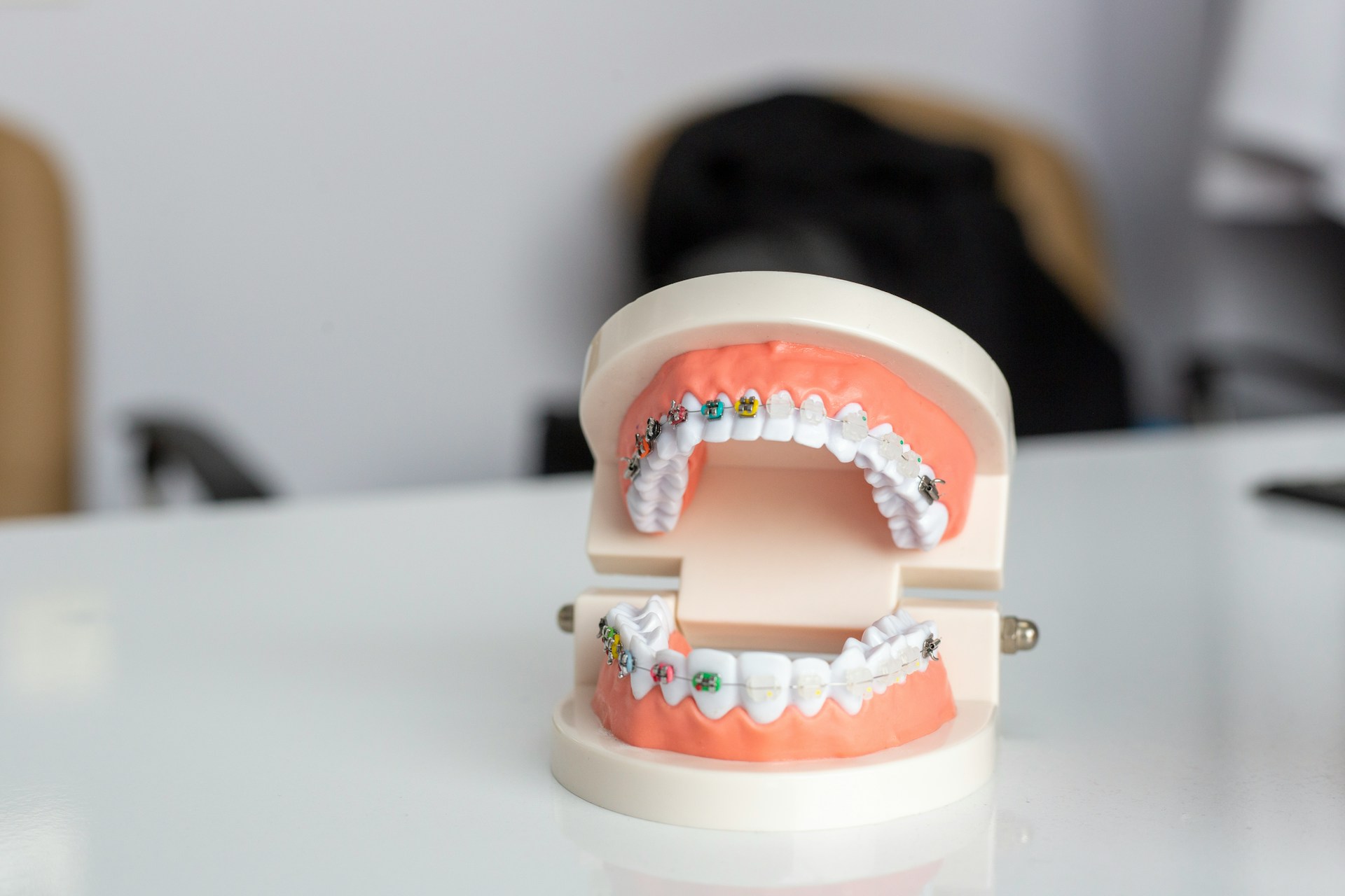 Modelo dental con brackets de colores en dientes superiores e inferiores